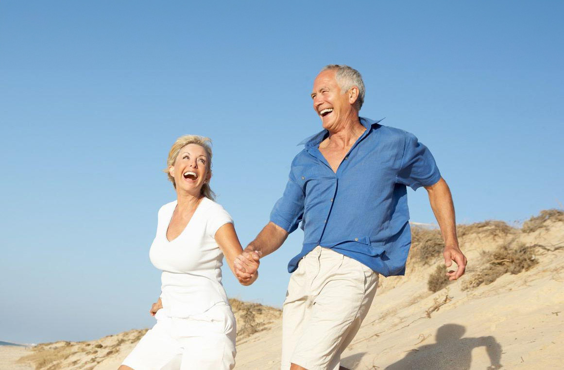A joyful older couple laughing together outdoors